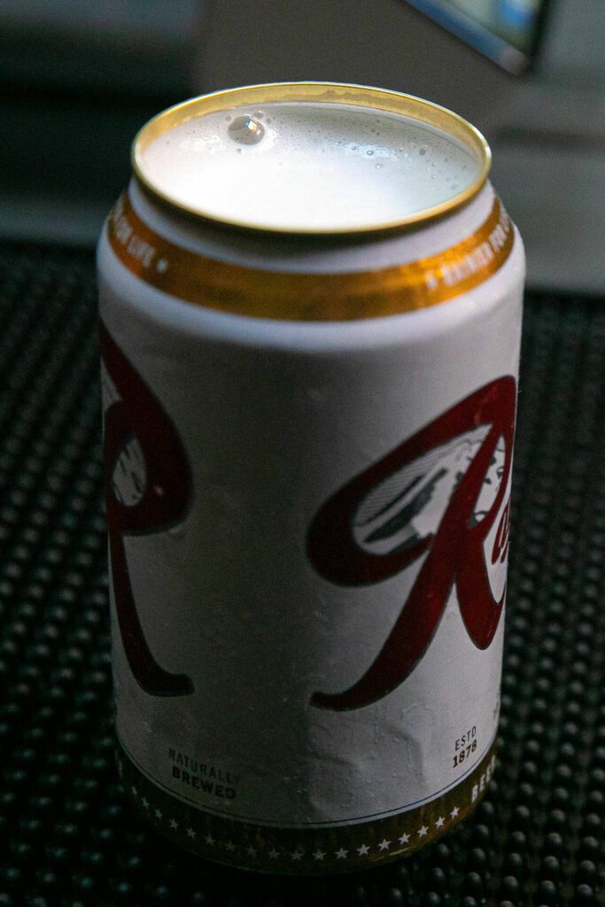 Rainiers are served topless at Obsidian Beer Hall on Friday, April 12, 2024, in downtown Everett, Washington. (Ryan Berry / The Herald) 
