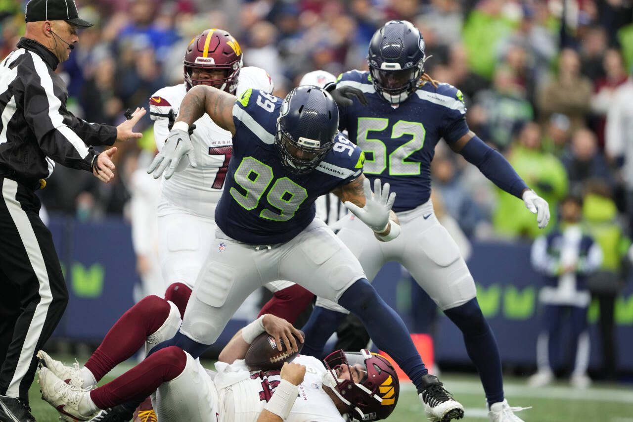Seattle Seahawks defensive end Leonard Williams (99) jumps over Washington Commanders quarterback Sam Howell (14) in the first half of an NFL football game in Seattle, Sunday, Nov. 12, 2023. (AP Photo/Lindsey Wasson)