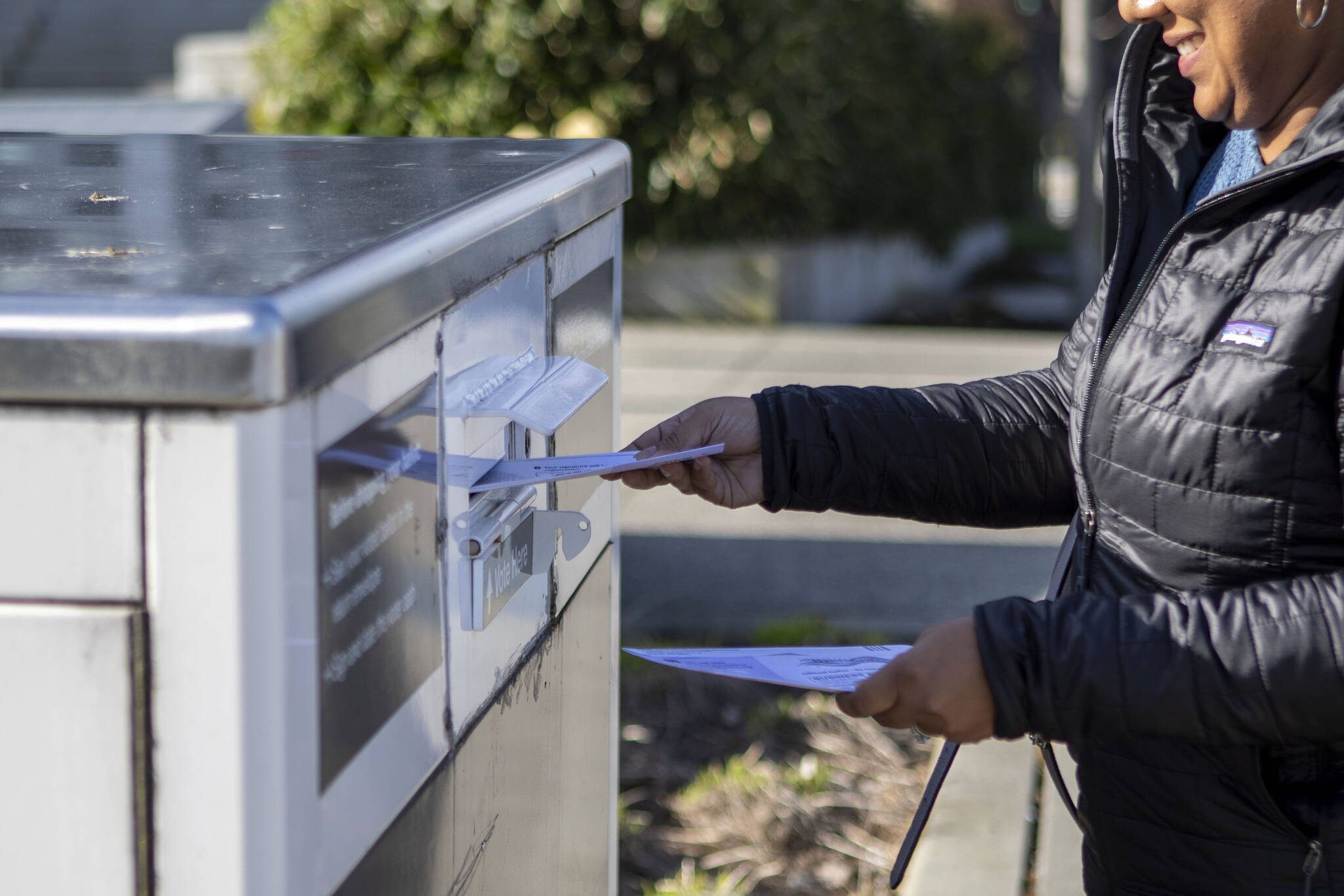 A voter turns in a ballot on Tuesday, Feb. 13, 2024, outside the Snohomish County Courthouse in Everett, Washington. (Annie Barker / The Herald)