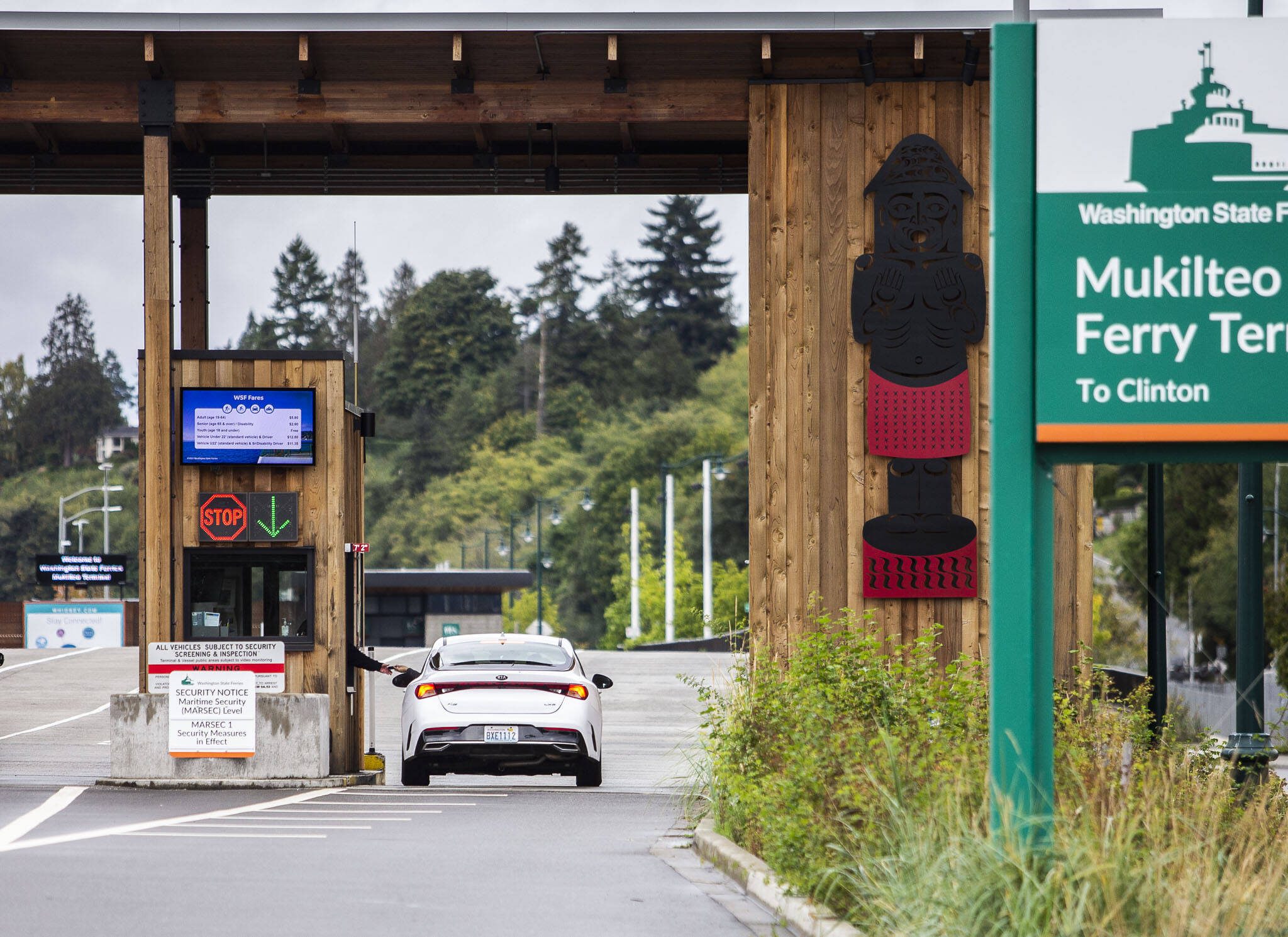 A passenger pays their fare before getting in line for the ferry on Thursday, Sept. 28, 2023 in Mukilteo, Washington. (Olivia Vanni / The Herald)