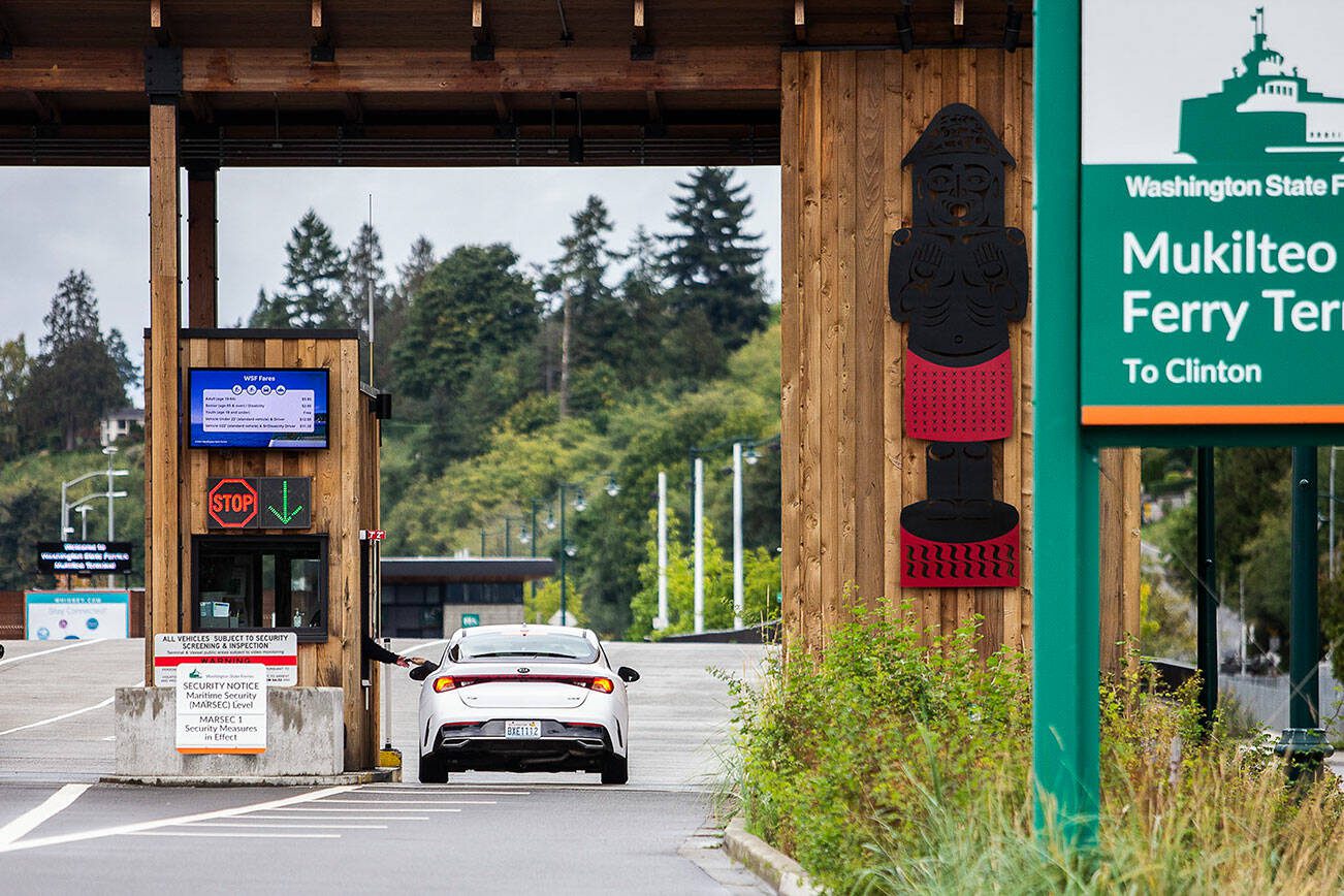 A passenger pays their fare before getting in line for the ferry on Thursday, Sept. 28, 2023 in Mukilteo, Washington. (Olivia Vanni / The Herald)