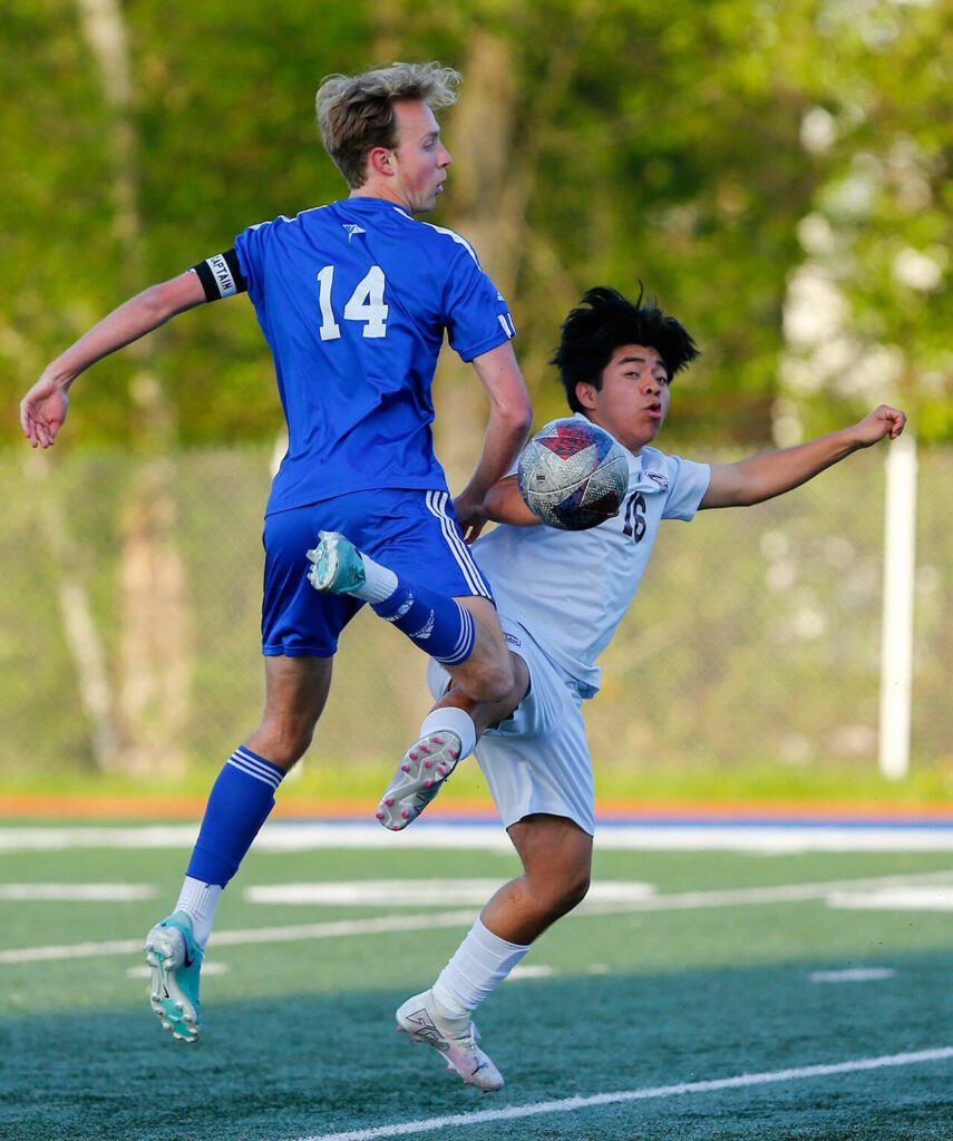 Shorewood defender Henry Franey and Cascade’s Alan Osorio both go for the ball during a boys soccer match on Monday, April 22, 2024, at Shoreline Stadium in Shoreline, Washington. (Ryan Berry / The Herald)
