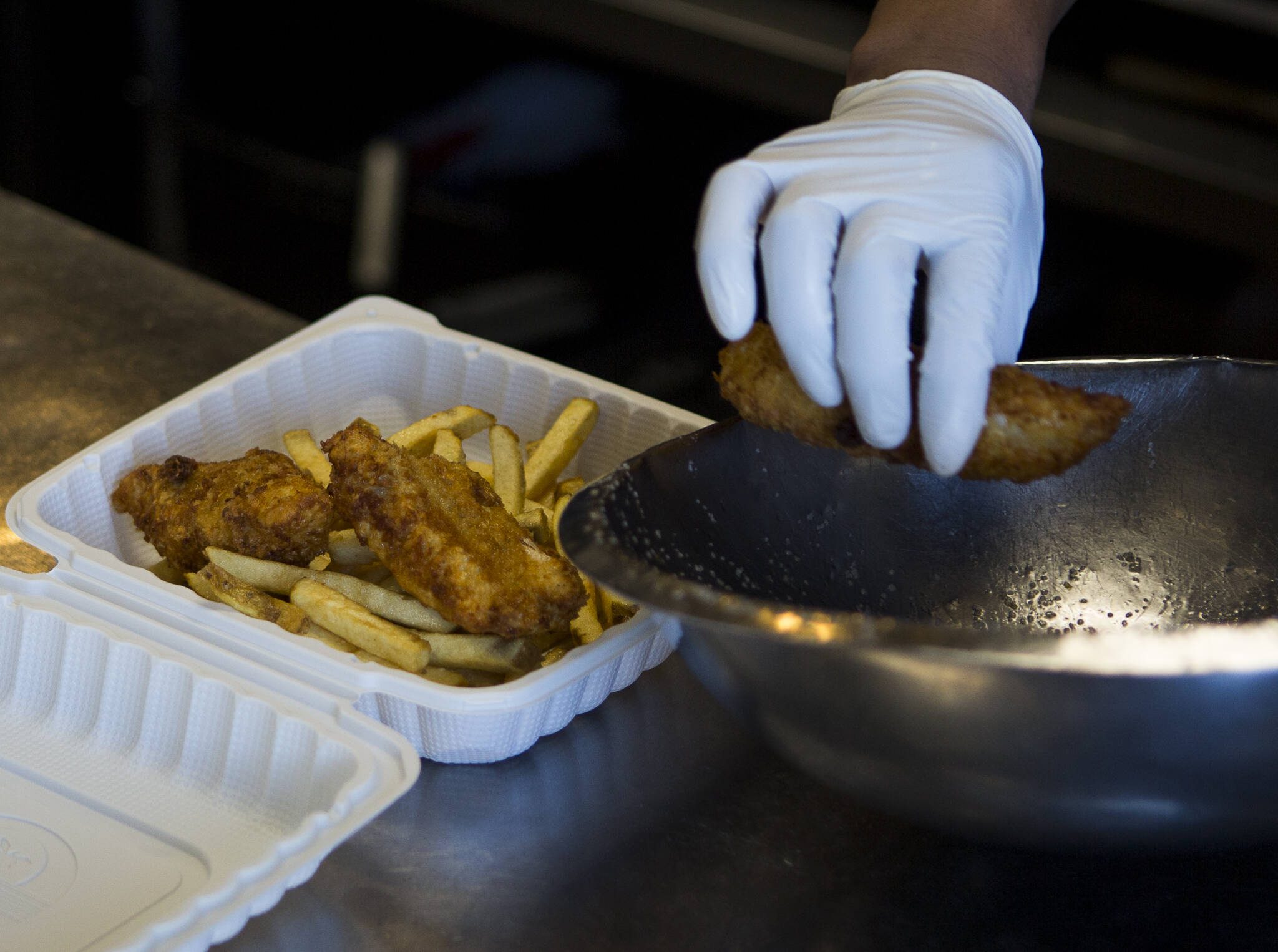 Andy’s Fish House cooks put together a three piece fish and chips order on Thursday, March 19, 2020 in Snohomish, Wa. (Olivia Vanni / The Herald)