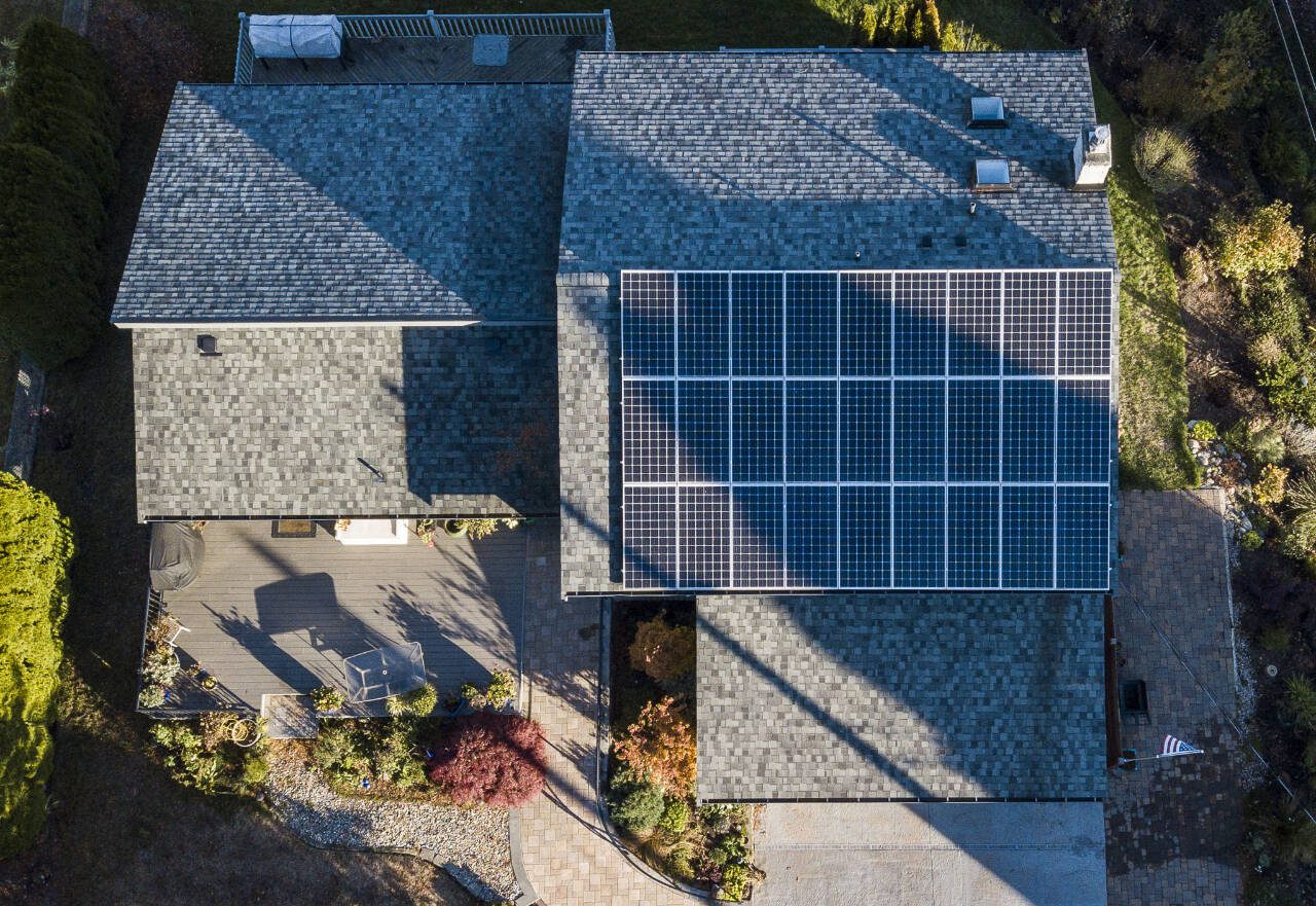 Solar panels are visible on the rooftop of a home in Everett in November 2022. (Olivia Vanni / The Herald file photo)
