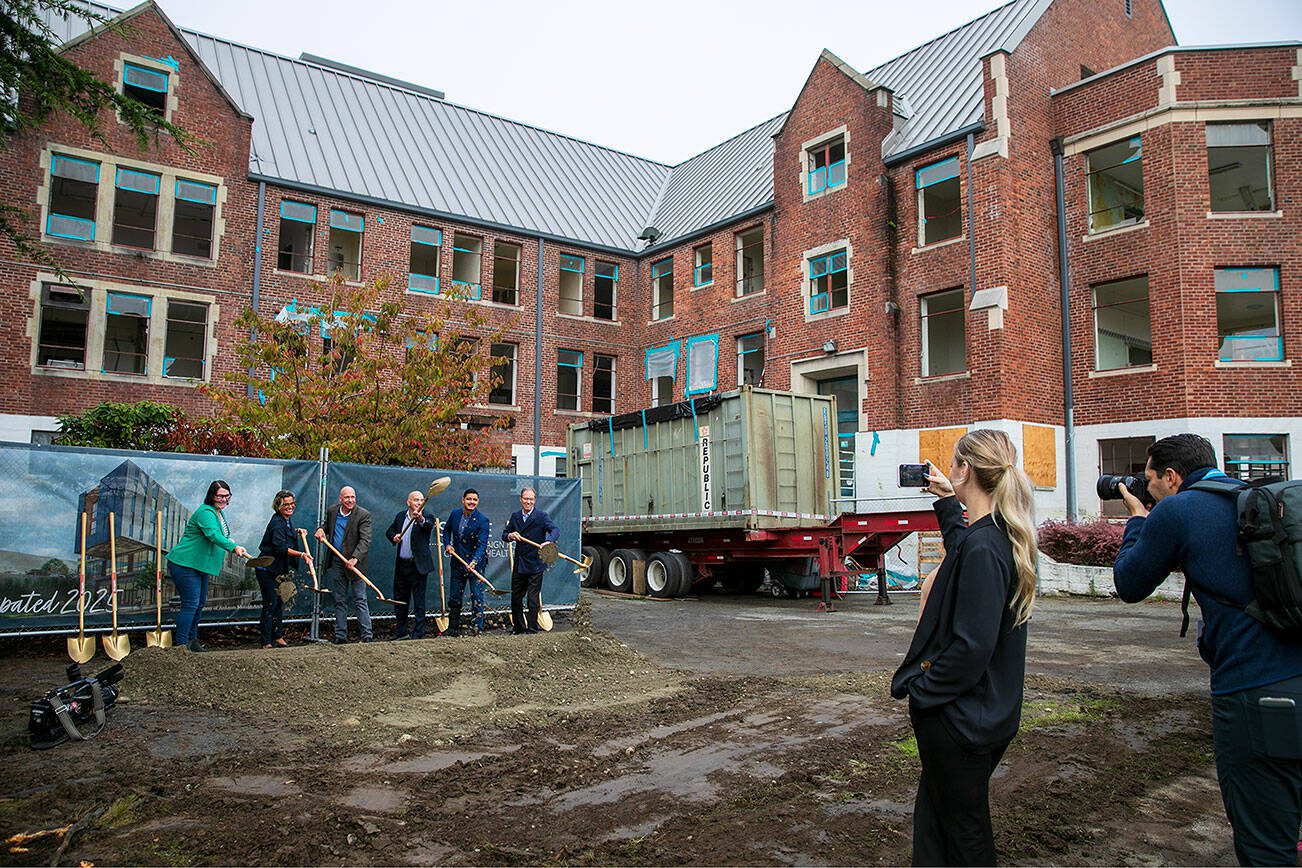 A group including Everett Mayor Cassie Franklin, Compass Health CEO Tom Sebastian, Sen. Keith Wagoner and Rep. Julio Cortes take their turn breaking ground during a ceremony celebrating phase two of Compass Health’s Broadway Campus Redevelopment project Thursday, Oct. 12, 2023, in Everett, Washington. (Ryan Berry / The Herald)