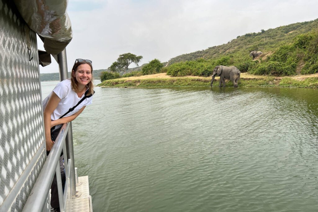 Kim Tate, author of the travel blog Stuffed Suitcase, poses next to an elephant in Uganda. (Photo courtesy of Kim Tate)
