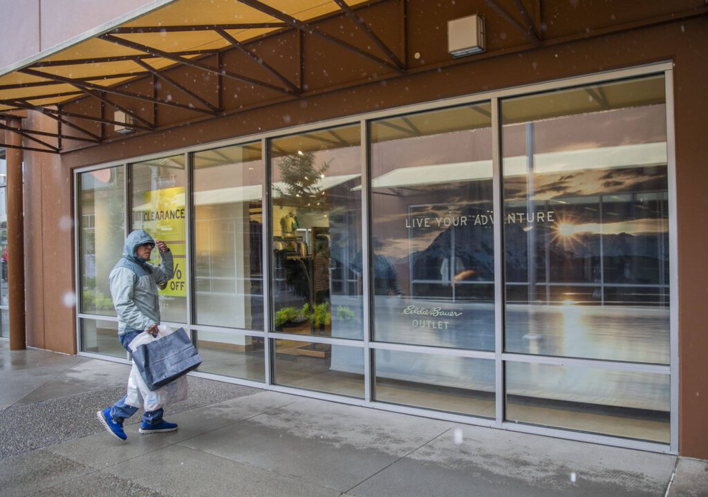 A shopper walks by the Eddie Bauer Outlet while it rains at Seattle Premium Outlets on Thursday, April 25, 2024 in Quil Ceda Village, Washington. (Olivia Vanni / The Herald)
