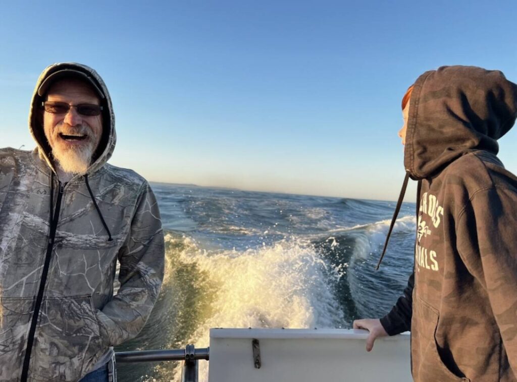 John Wightman stands on a charter boat with his grandson Jaxon at his family’s annual fishing trip out of Westport, Washington in June 2023. (Photo provided by Kristen Velez)
