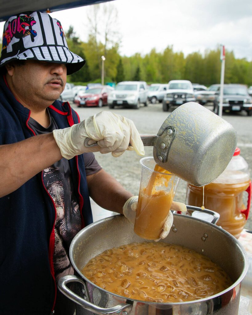 Fernando Pedresa pours a tall cup of tejuino, a fermented corn beverage, at the Hidden Gems Weekend Market on Sunday, April 28, 2024, at Boom City in Tulalip, Washington. (Ryan Berry / The Herald)
