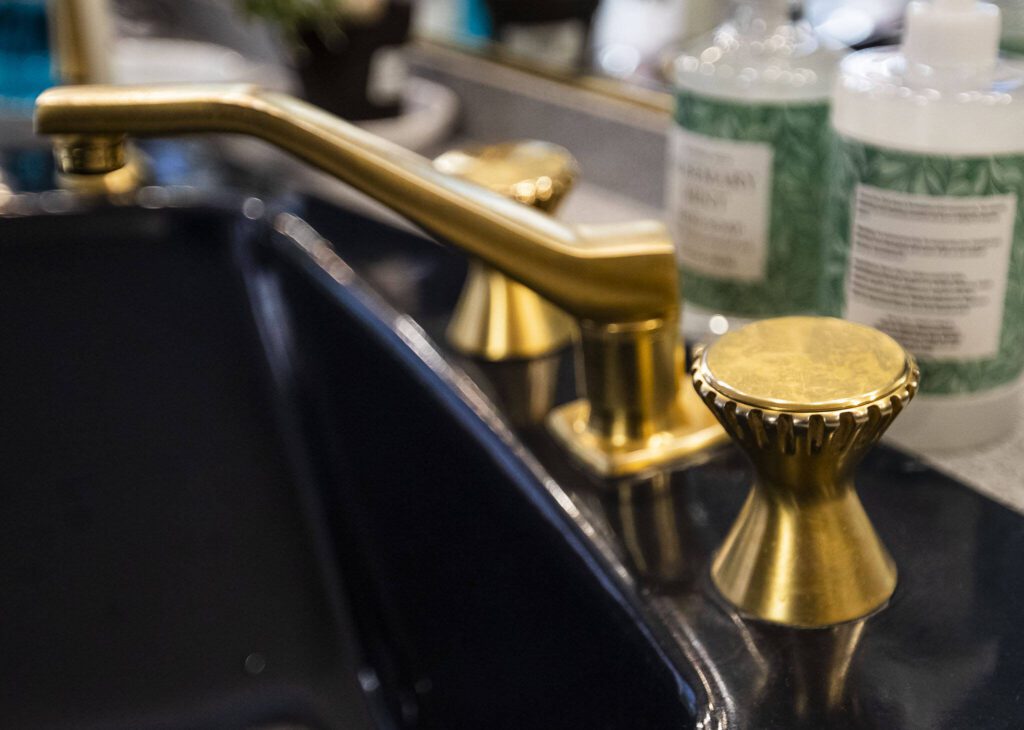 Gold plated sink fixtures in a bathroom. (Olivia Vanni / The Herald)
