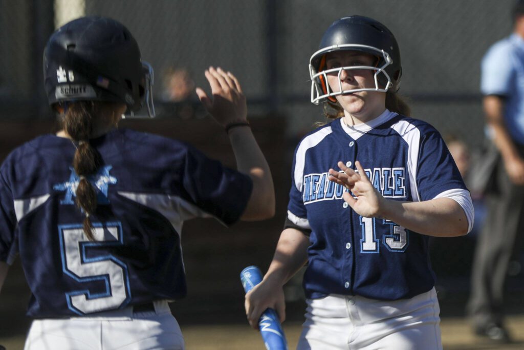 Meadowdale players high-five during a softball game between Meadowdale and Marysville Getchell on Wednesday, May 1, 2024 in Marysville, Washington. Meadowdale won, 12-9. (Annie Barker / The Herald)
