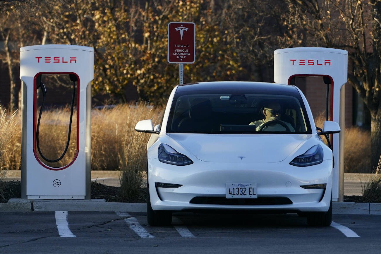 A Tesla electric vehicle is seen at a Tesla electric vehicle charging station at Willow Festival shopping plaza parking lot in Northbrook, Ill., Saturday, Dec. 3, 2022. A Tesla driver who had set his car on Autopilot was “distracted” by his phone before reportedly hitting and killing a motorcyclist Friday on Highway 522, according to a new police report. (AP Photo/Nam Y. Huh)