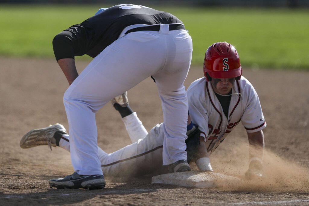 Snohomish’s Rider Walsh (14) slides back to first during a District 1 3A baseball game between Meadowdale and Snohomish at Snohomish High School on Monday, April 30, 2024 in Snohomish, Washington. Snohomish won, 3-1. (Annie Barker / The Herald)
