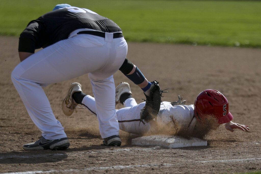 Snohomish’s Chase Clark (5) dives for first while trying to steal during a District 1 3A baseball game between Meadowdale and Snohomish at Snohomish High School on Monday, April 30, 2024 in Snohomish, Washington. Snohomish won, 3-1. (Annie Barker / The Herald)
