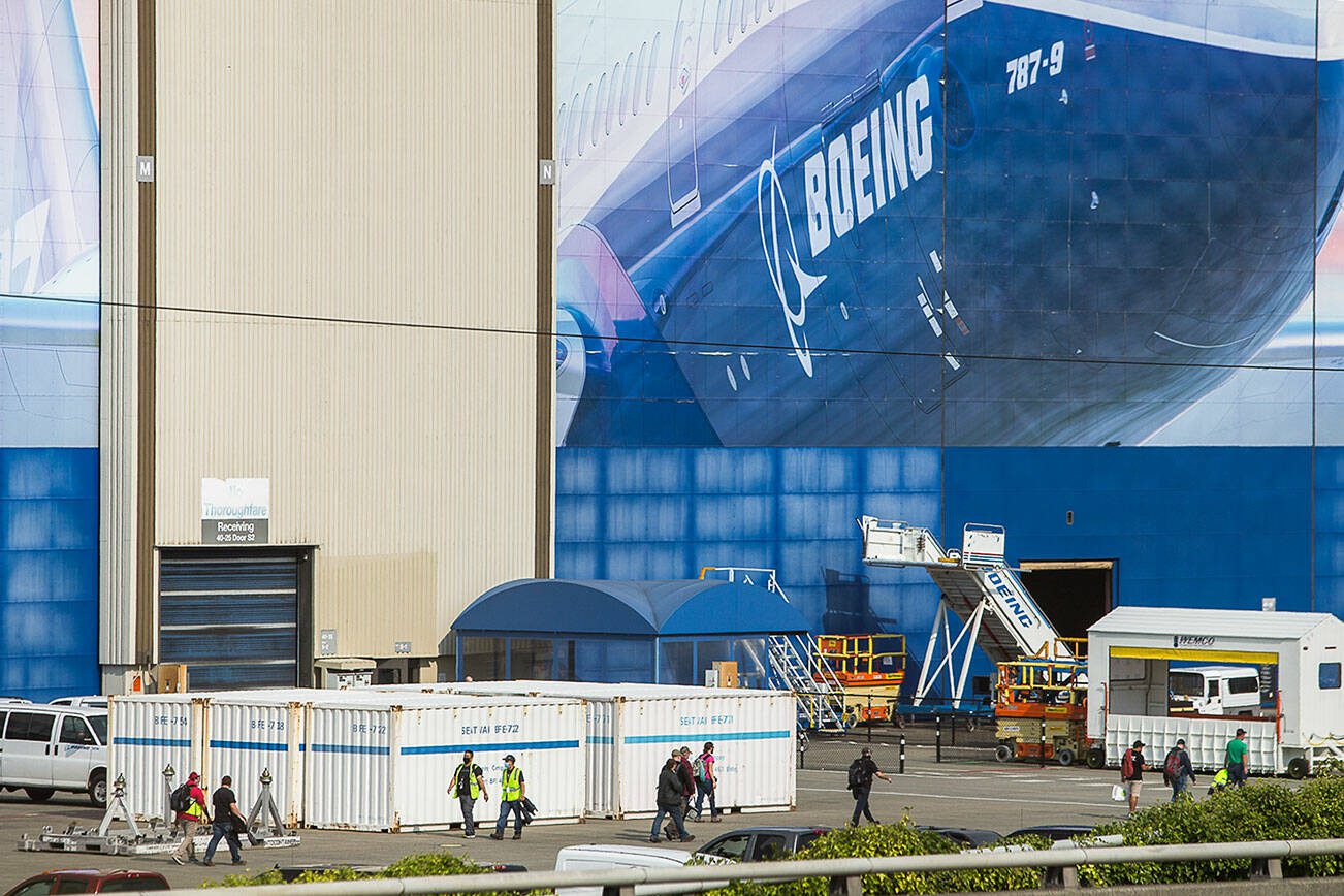 Boeing workers walk to and from their cars during a shift change on Thursday, Oct. 1, 2020 in Everett, Wa. (Olivia Vanni / The Herald)