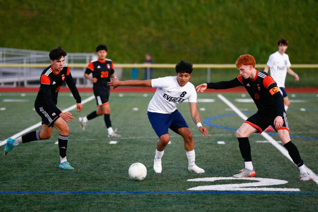 Everett’s Liang Jimenez plays keep away from multiple defenders during a 3A District soccer match against Monroe on Thursday, May 2, 2024, at Monroe High School in Monroe, Washington. (Ryan Berry / The Herald)
