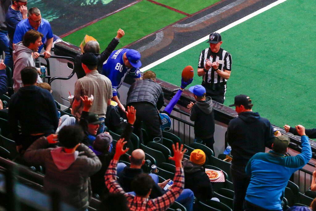 An official signals a completion after a wild catch by JR Nelson that sent him flying into the stands during the Washington Wolfpack’s inaugural home opener against Billings on Sunday, May 5, 2024, a Angel of the Winds Arena in Everett, Washington. (Ryan Berry / The Herald)
