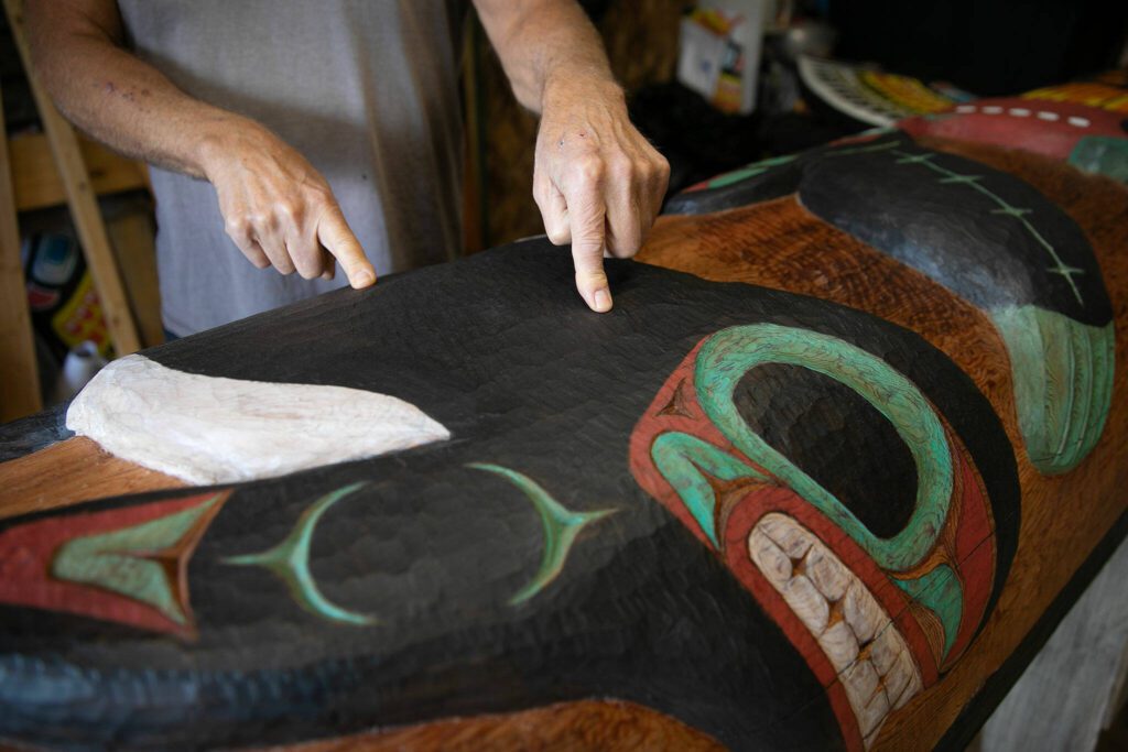 Tlingit Artist Fred Fulmer points to some of the texture work he did on an information totem pole on Wednesday, May 8, 2024, at his home in Everett, Washington. (Ryan Berry / The Herald)
