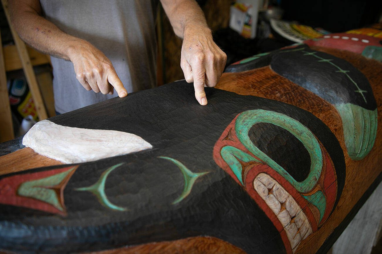Tlingit Artist Fred Fulmer points to some of the texture work he did on his information totem pole on Wednesday, May 8, 2024, at his home in Everett, Washington. (Ryan Berry / The Herald)