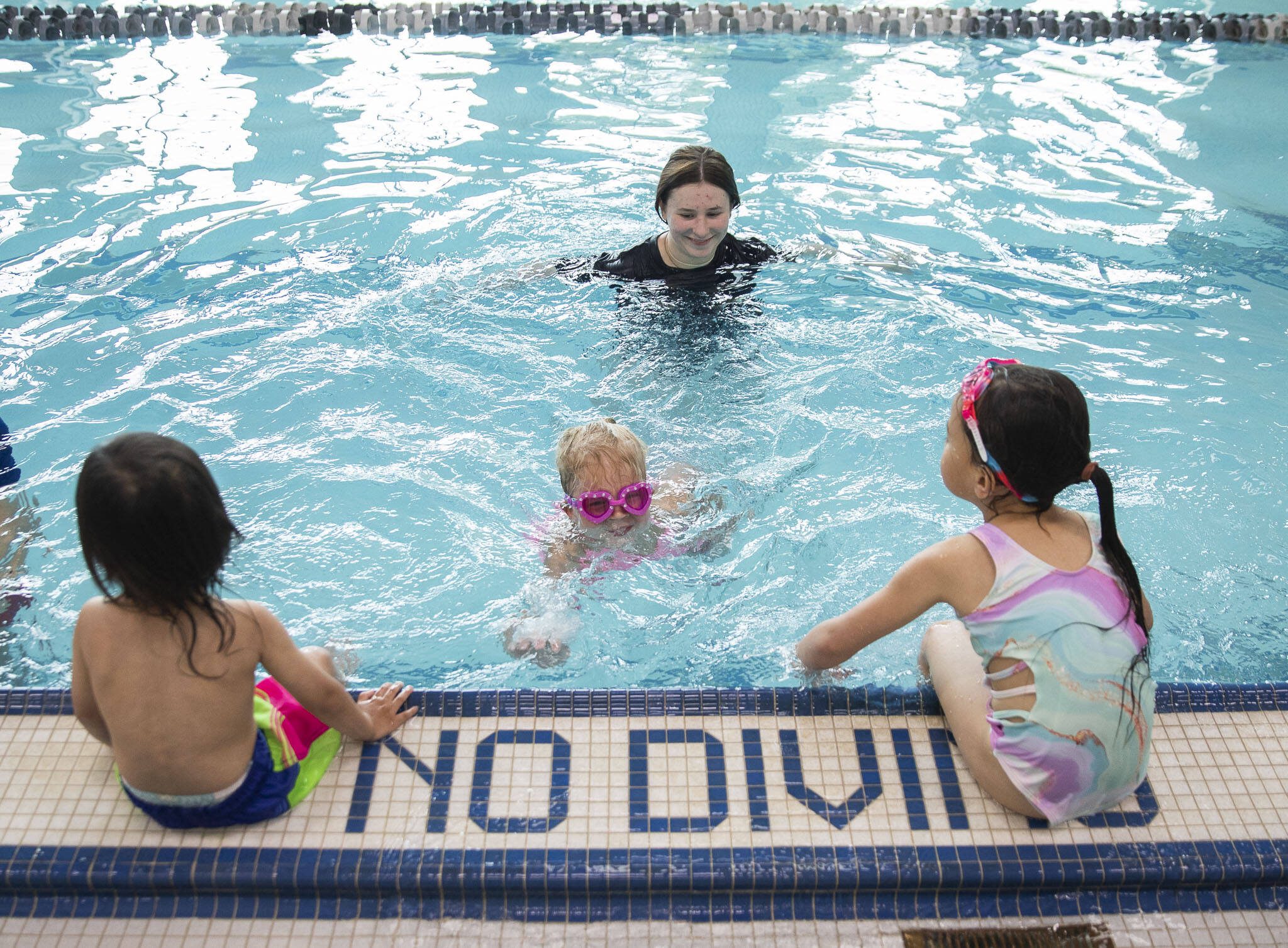 YMCA swim instructor Olivia Beatty smiles as Claire Lawson, 4, successfully swims on her own to the wall during Swim-a-palooza, a free swim lesson session, at Mill Creek Family YMCA on Saturday, May 18, 2024 in Mill Creek, Washington. (Olivia Vanni / The Herald)
