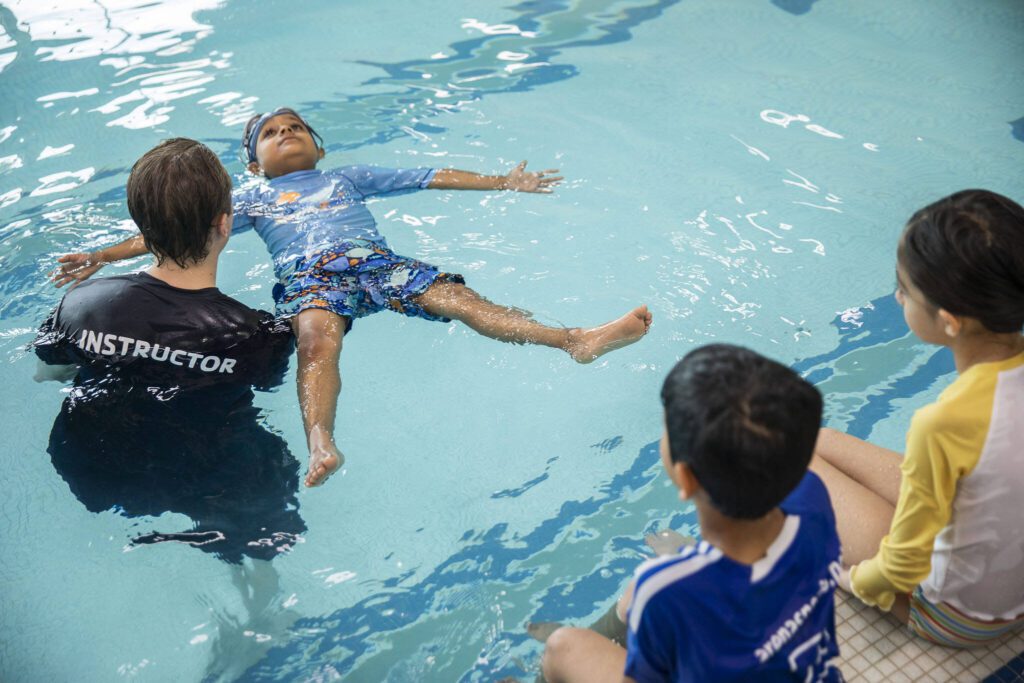 YMCA swim instructor Brandon Kissinger helps Shankar Vijay, 5, float on his back during Swim-a-palooza, a free swim lesson session, at Mill Creek Family YMCA on Saturday, May 18, 2024 in Mill Creek, Washington. (Olivia Vanni / The Herald)
