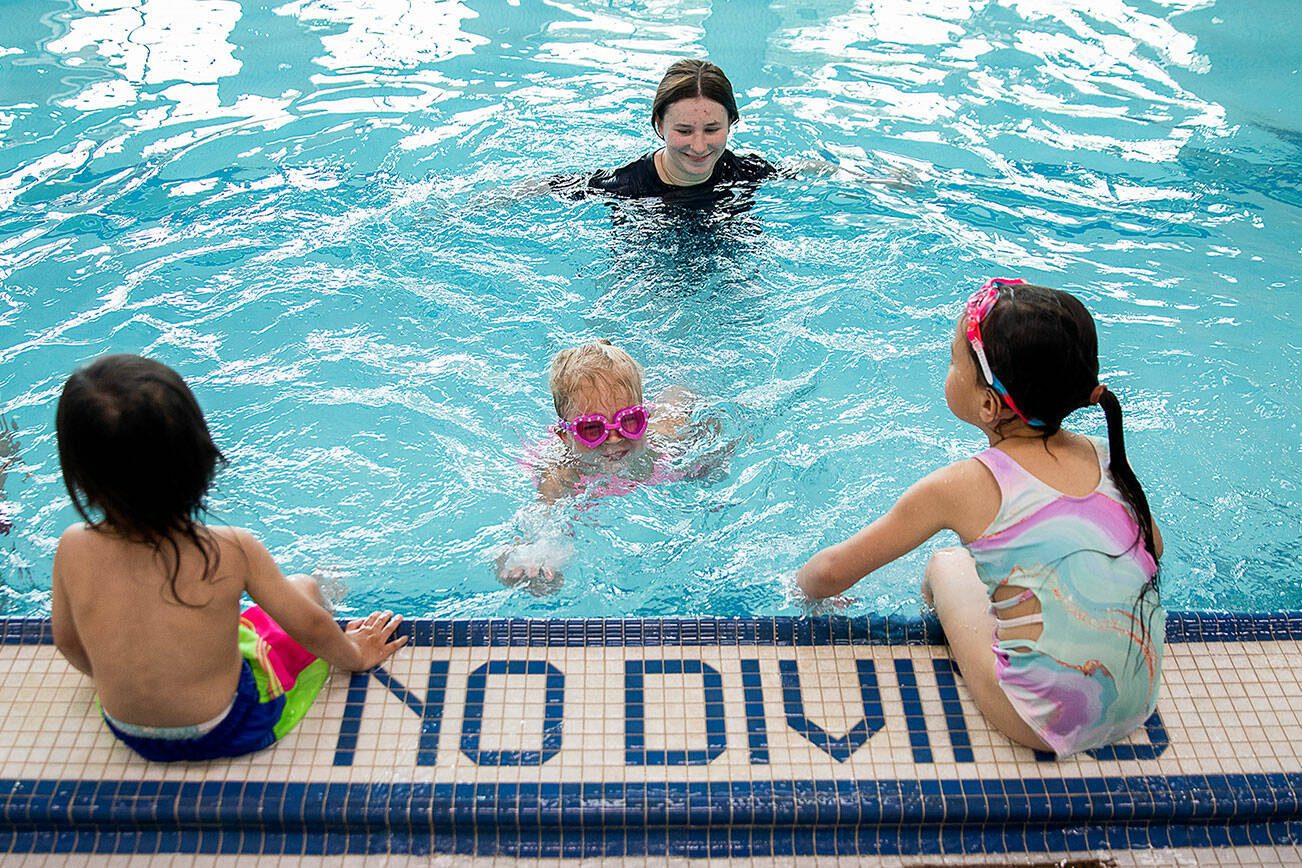 YMCA swim instructor Olivia Beatty smiles as Claire Lawson, 4, successfully swims on her own to the wall during Swim-a-palooza, a free swim lesson session, at Mill Creek Family YMCA on Saturday, May 18, 2024 in Mill Creek, Washington. (Olivia Vanni / The Herald)