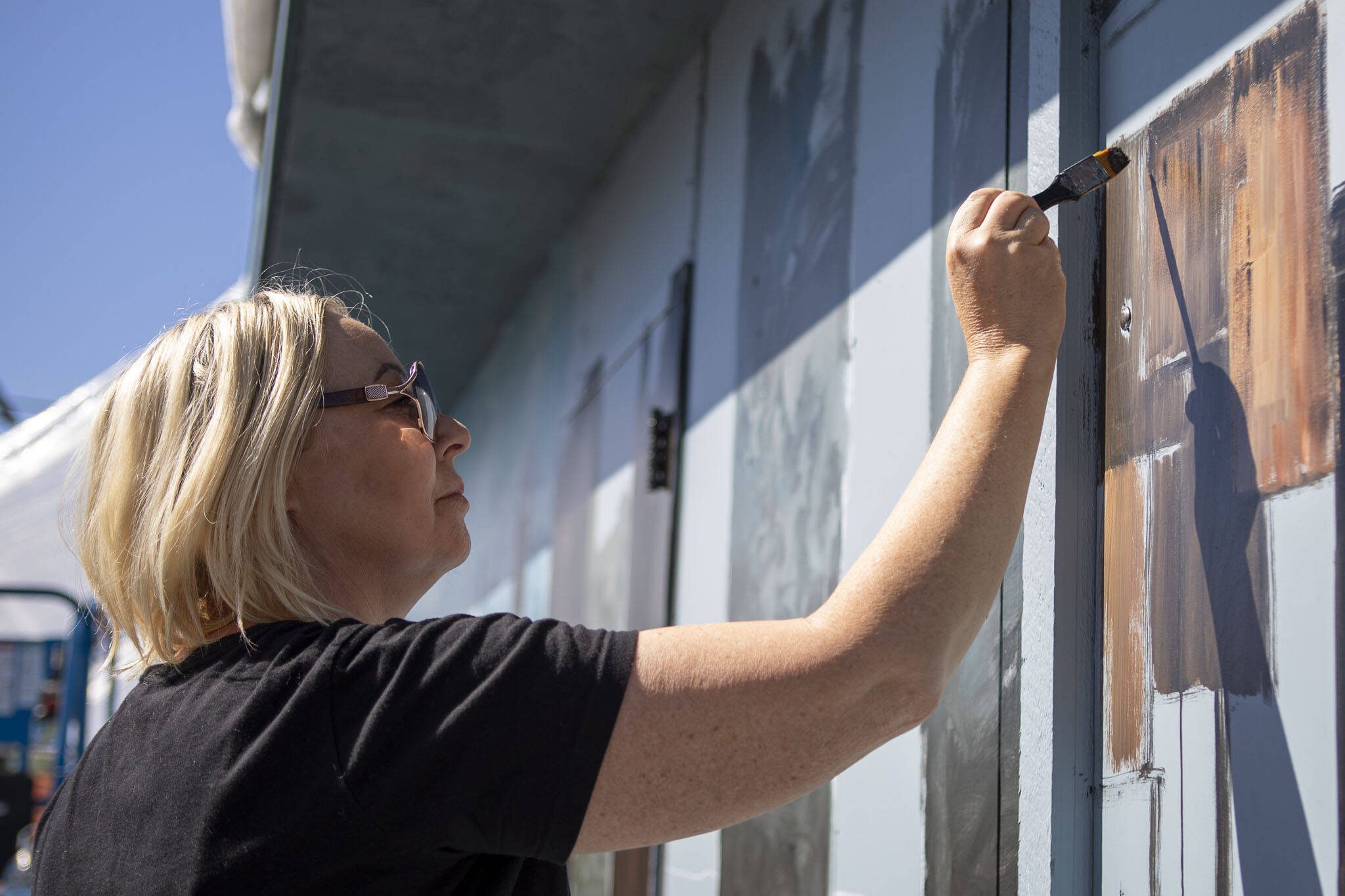 Gina Ribaudo works on a mural at the intersection of Colby and Pacific for the Imagine Children’s Museum in Everett, Washington on Thursday, May 9, 2024. (Annie Barker / The Herald)