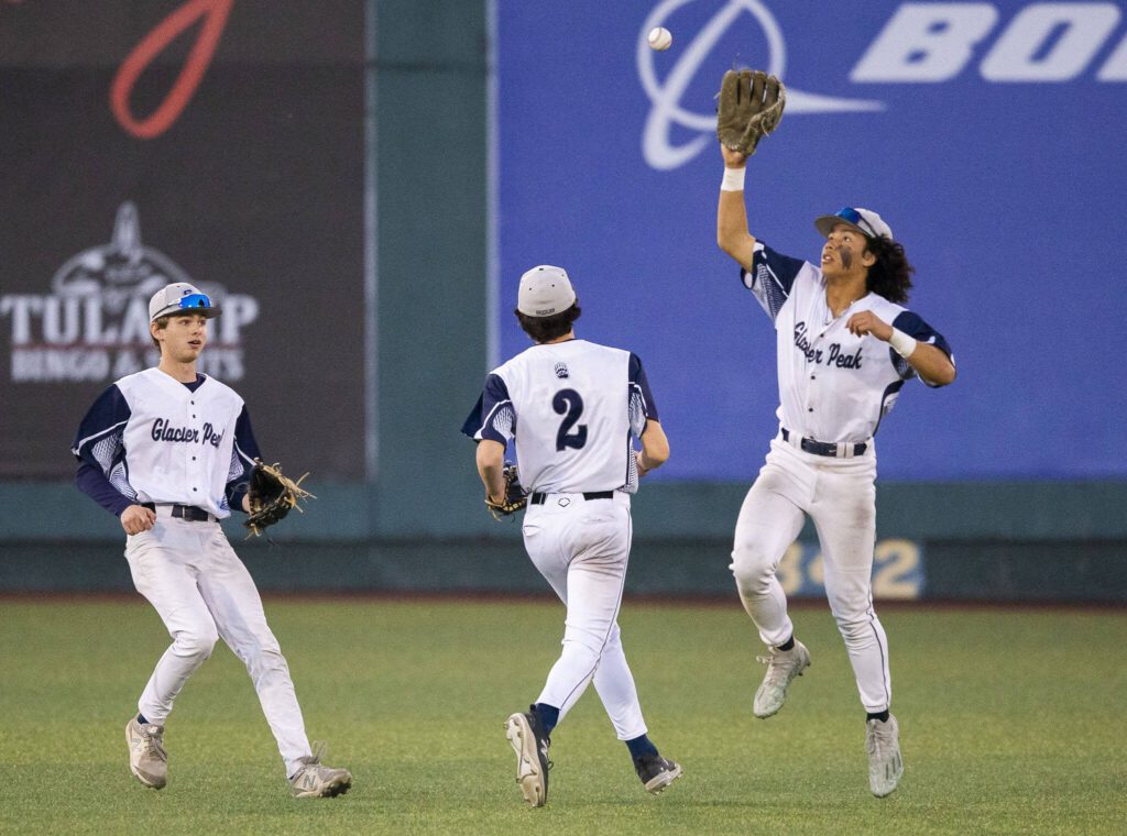 Glacier Peak’s Atticus Quist leaps in the air to catch a bouncing baseball after a missed catch in the outfield during the 4A district game against Bothell at Funko Field on Thursday, May 9, 2024 in Everett, Washington. (Olivia Vanni / The Herald)
