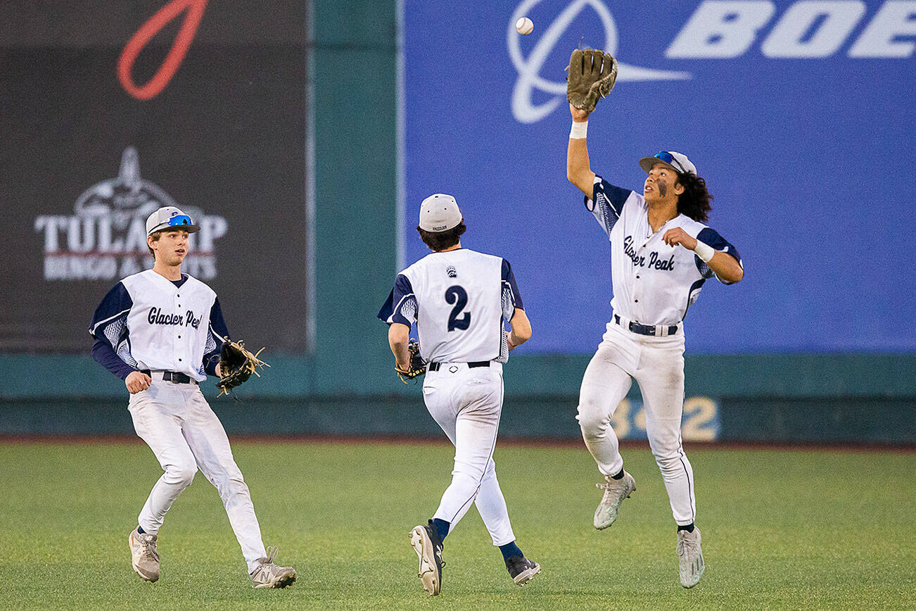 Glacier Peak’s Atticus Quist leaps in the air to catch a bouncing baseball after a missed catch in the outfield during the 4A district game against Bothell at Funko Field on Thursday, May 9, 2024 in Everett, Washington. (Olivia Vanni / The Herald)