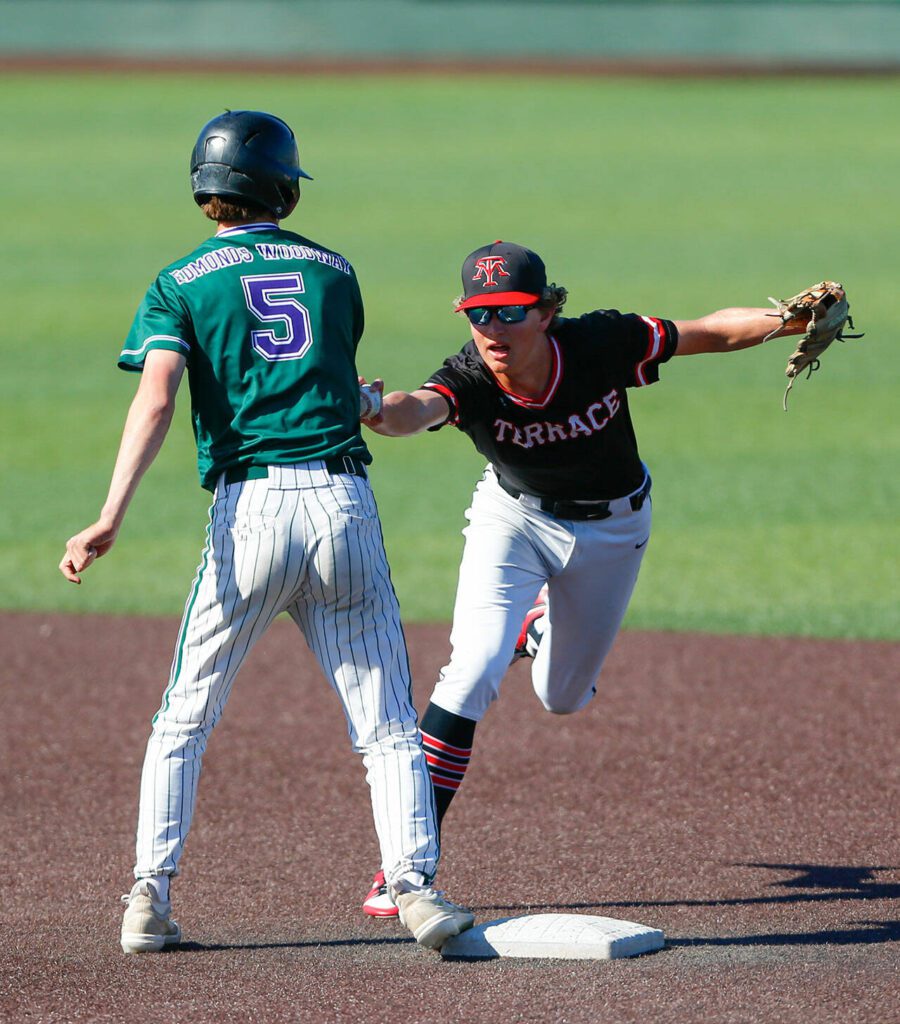 Edmonds-Woodway’s Luke Boland gets back to the bag safely on a wild throw by Mountlake Terrace in the Class 3A District 1 baseball championship Saturday, May 11, 2024, at Funko Field in Everett, Washington. (Ryan Berry / The Herald)
