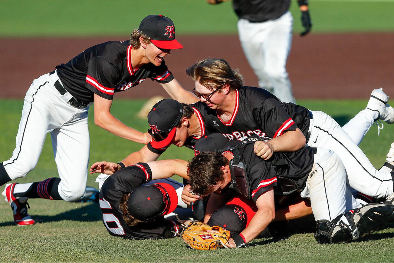 Mountlake Terrace teammates dogpile on pitcher Owen Meek after his complete game victory against Edmonds-Woodway in the Class 3A District 1 baseball championship Saturday, May 11, 2024, at Funko Field in Everett, Washington. (Ryan Berry / The Herald)