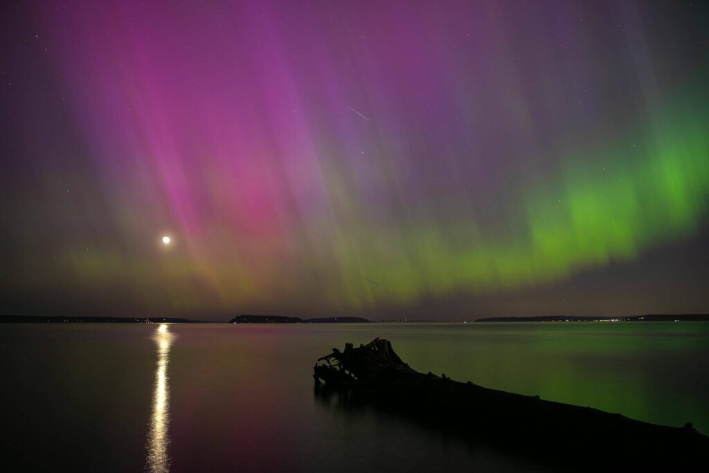 The aurora borealis appears over the Puget Sound on the night of Friday, May 10, 2024, seen from Howarth Park in Everett, Washington. (Ryan Berry / The Herald)
