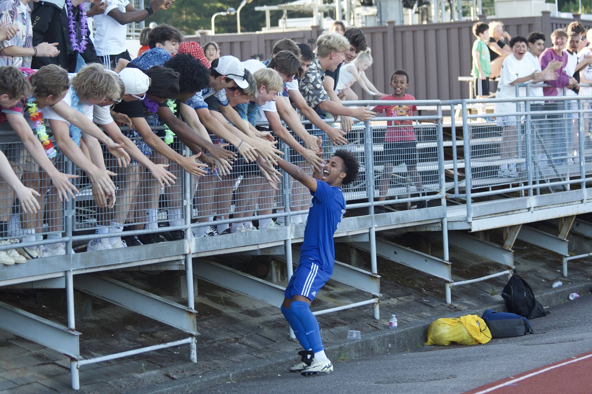 Shorewood senior forward Isaak Abraham celebrates with fans after scoring a goal during the Class 3A District 1 title game Saturday at Shoreline Stadium. The Stormrays won 2-1 against Edmonds-Woodway. (Taras McCurdie / The Herald)
