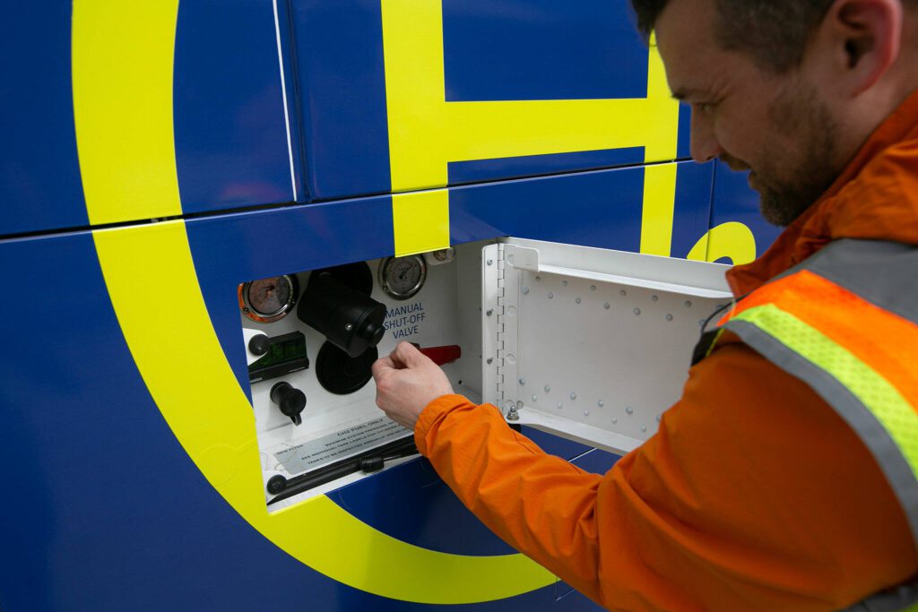 Mike Swehla, Director of Maintenance for Community Transit, jimmies open the fueling port on a hydrogen-powered, zero-emission bus on Monday, May 13, 2024, at the Community Transit Operations Base in Everett, Washington. (Ryan Berry / The Herald)
