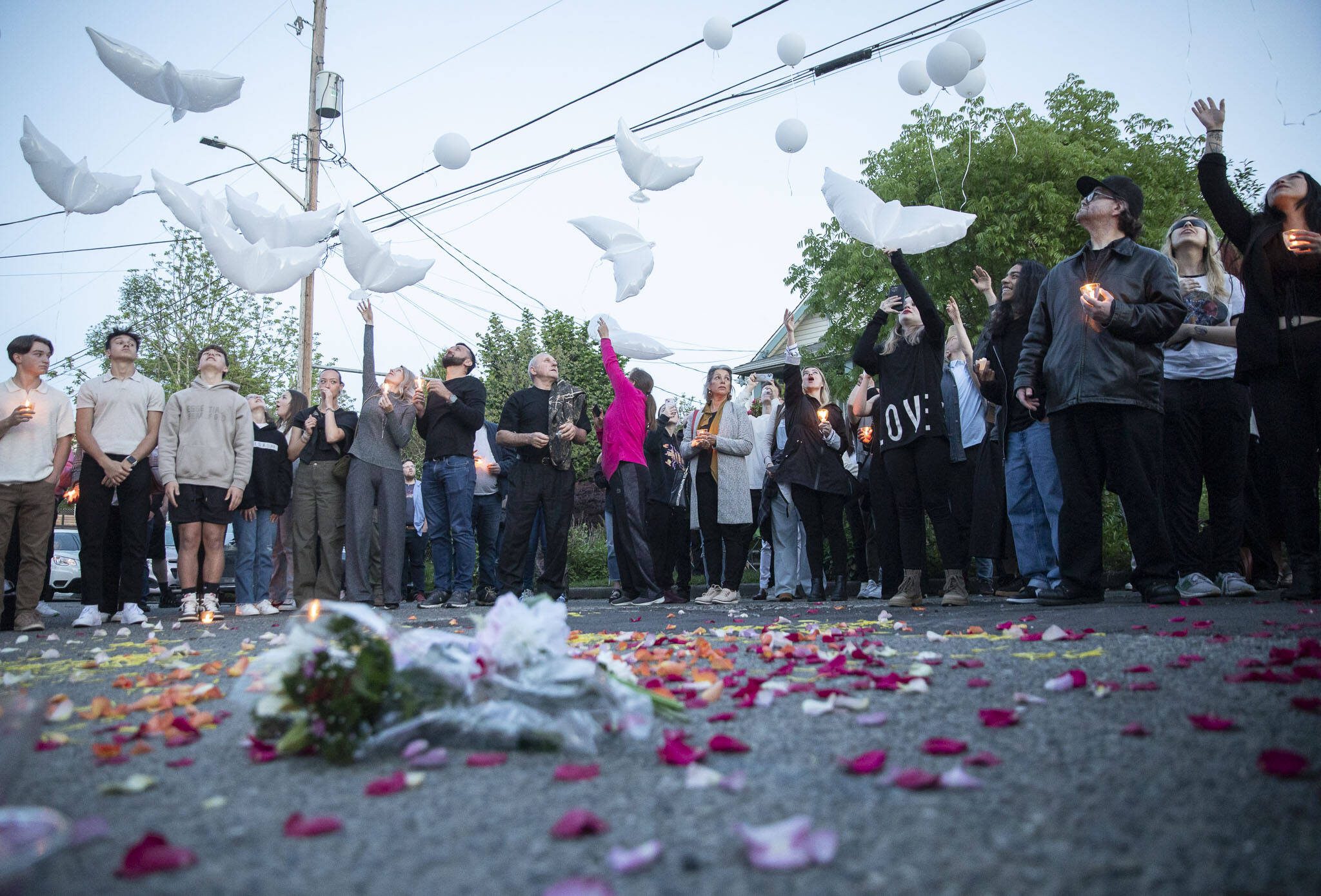 Family and friends of Liliya Guyvoronsky send up white balloons at a vigil held outside her home on Tuesday, May 14, 2024, in Seattle, Washington. (Olivia Vanni / The Herald)