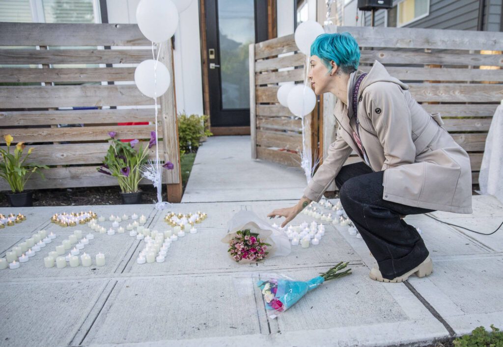 Makyla D. places flowers outside of the home of Liliya Guyvoronsky during a vigil on Tuesday, May 14, 2024 in Seattle, Washington. (Olivia Vanni / The Herald)
