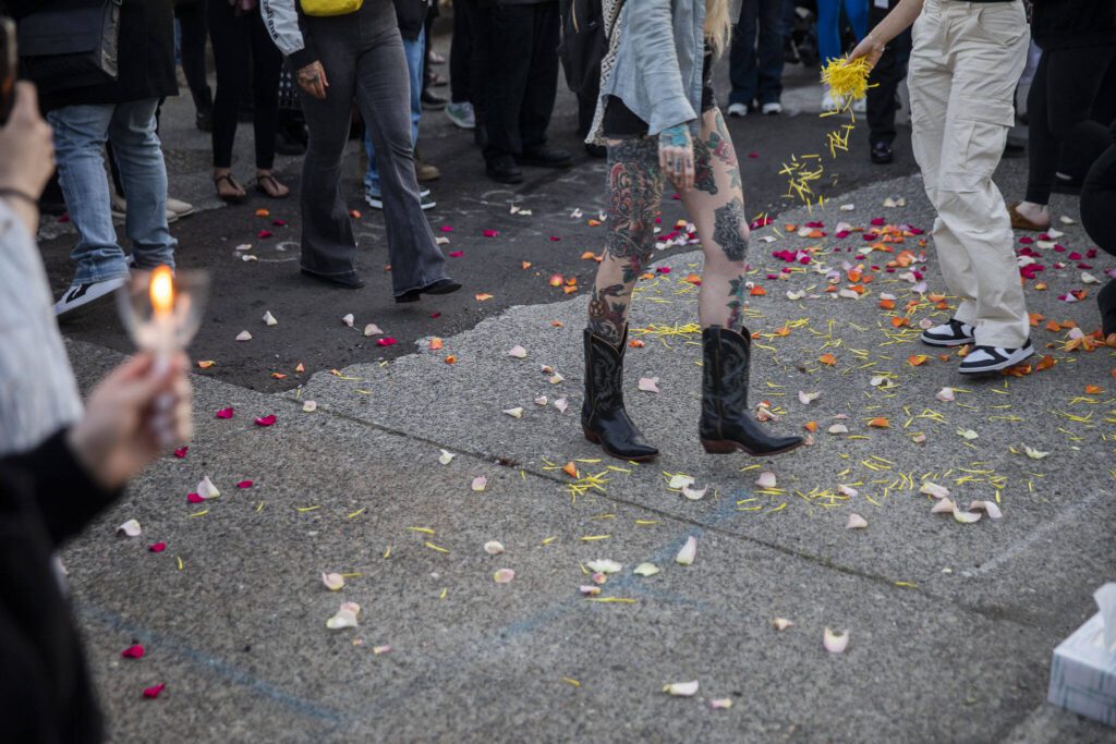 People spread flower petals on the ground after during a vigil held in memory of Liliya Guyvoronsky on Tuesday, May 14, 2024 in Seattle, Washington. (Olivia Vanni / The Herald)
