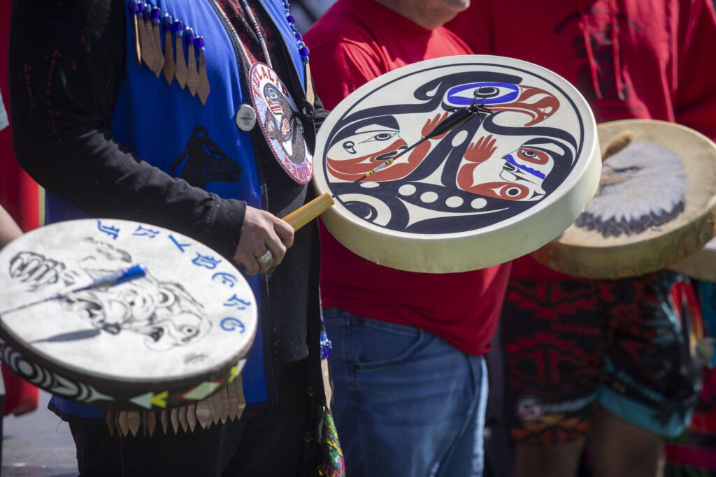 People drum during a blessing song during a ceremony for the healing pole students spent the last year carving along with Tulalip carver James Madison at Archbishop Murphy High School in Everett, Washington on Wednesday, May 15, 2024. (Annie Barker / The Herald)

