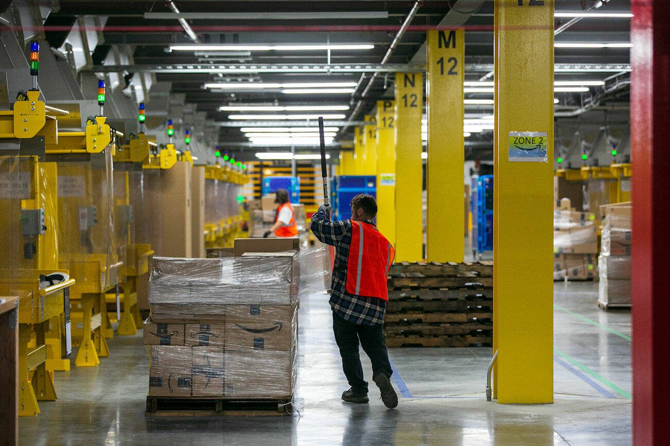 Amazon workers wrap up pallets of orders for shipment at the new PAE2 Amazon Fulfillment Center on Thursday, Sept. 14, 2023, in Arlington, Washington. (Ryan Berry / The Herald)