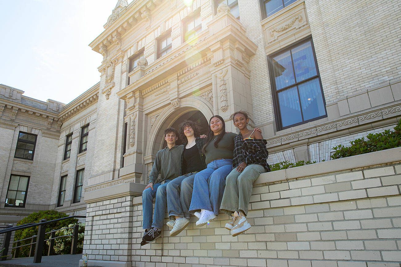 Everett High seniors, from left, Avery Thompson, Lanie Thompson, Melissa Rosales-Alfaro and Saron Mulugeta sit together in front of their school on Monday, May 20, 2024, in Everett, Washington. The group have called to question their district’s policy that does not permit graduates to decorate their mortarboards or graduation clothing. (Ryan Berry / The Herald)