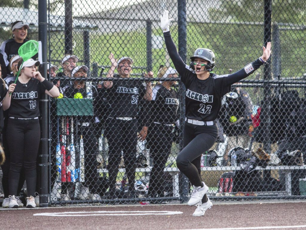 Jackson’s Allie Thomsen puts her arms up in celebration as she runs into home to score during the 4A district championship against Kamiak on Friday, May 17, 2024 in Everett, Washington. (Olivia Vanni / The Herald)
