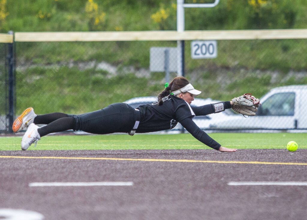 Jackson’s Rachel Sysum dives to try can stop a hit as it rolls into the outfield during the 4A district championship against Kaimiak on Friday, May 17, 2024 in Everett, Washington. (Olivia Vanni / The Herald)
