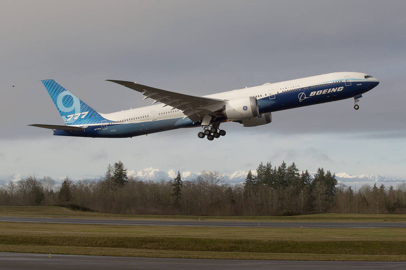 With the Olympic mountains in the background, Boeing's 777x lifts off from Paine Field on its first flight, to Boeing Field in Seattle, on Saturday, Jan. 25, 2020 in Everett, Wash. (Andy Bronson / The Herald)