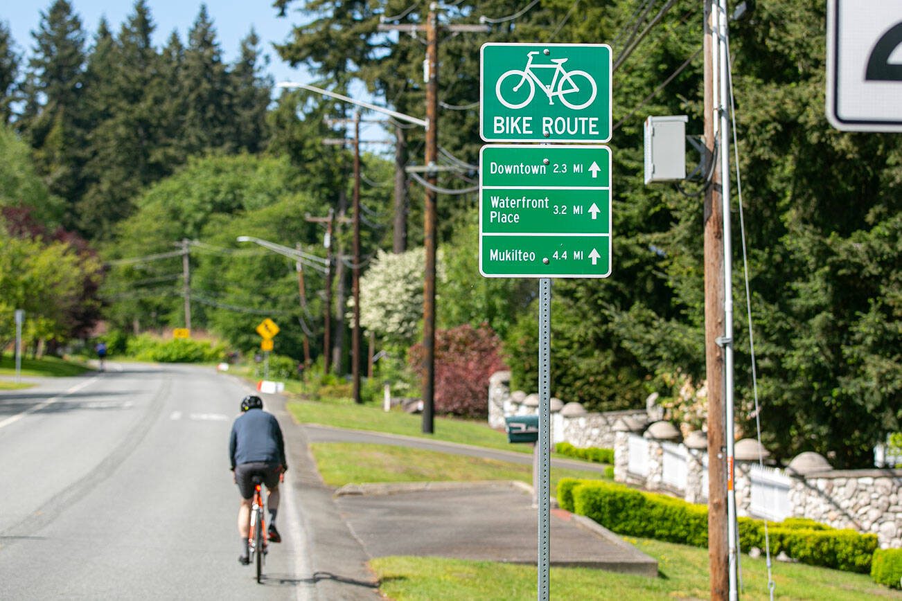 A cyclist heads along Federal Avenue past a bike route sign near 46th Street SE on Thursday, May 23, 2024, in Everett, Washington. (Ryan Berry / The Herald)