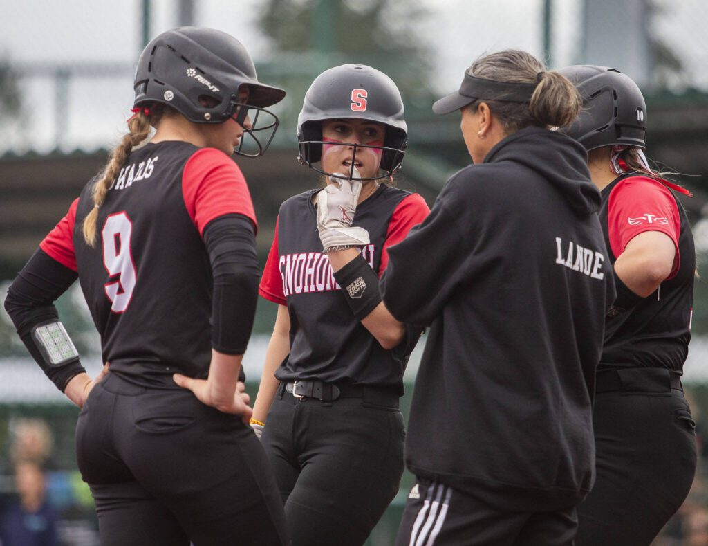 Snohomish players talk with their coach during the 3A state softball championship game against Auburn Riverside on Saturday, May 25, 2024 in Lacey, Washington. (Olivia Vanni / The Herald)
