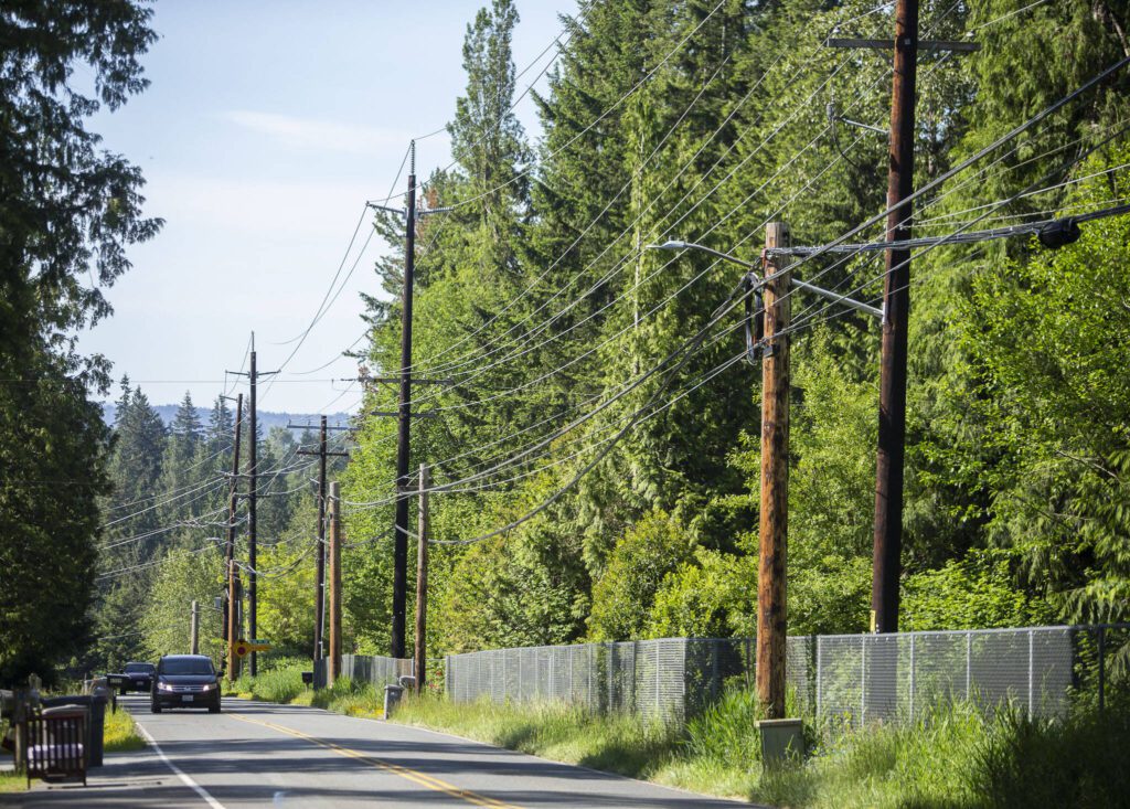 Cars drives along 103rd Avenue SE past power lines on Friday, May 31, 2024 in Lake Stevens, Washington. (Olivia Vanni / The Herald)
