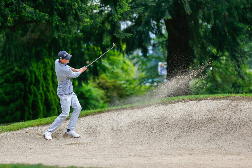 Conrad Chisman chips out of the bunker during the 93rd Annual Snohomish County Amateur Championship on Monday, May 27, 2024, at the Everett Golf and Country Club in Everett, Washington. (Ryan Berry / The Herald)
