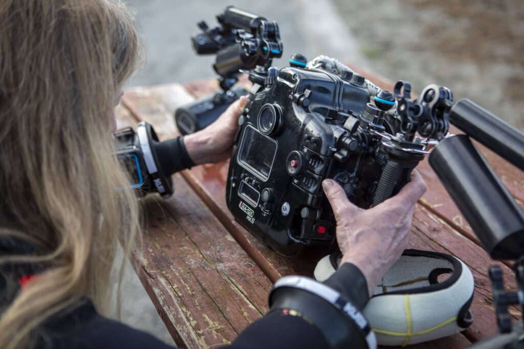 Annie Crawley demonstrates how to set up her underwater photography gear at Brackett’s Landing near the Port of Edmonds on Saturday, Feb. 3, 2024 in Edmonds, Washington. (Annie Barker / The Herald)
