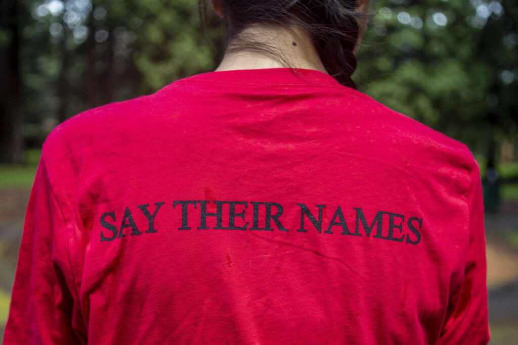 Gerry Davis poses for a photo with the words “Say Their Names” on her shirt at Hillcrest Park in Mount Vernon, Washington on Wednesday, May 29, 2024. (Annie Barker / The Herald)
