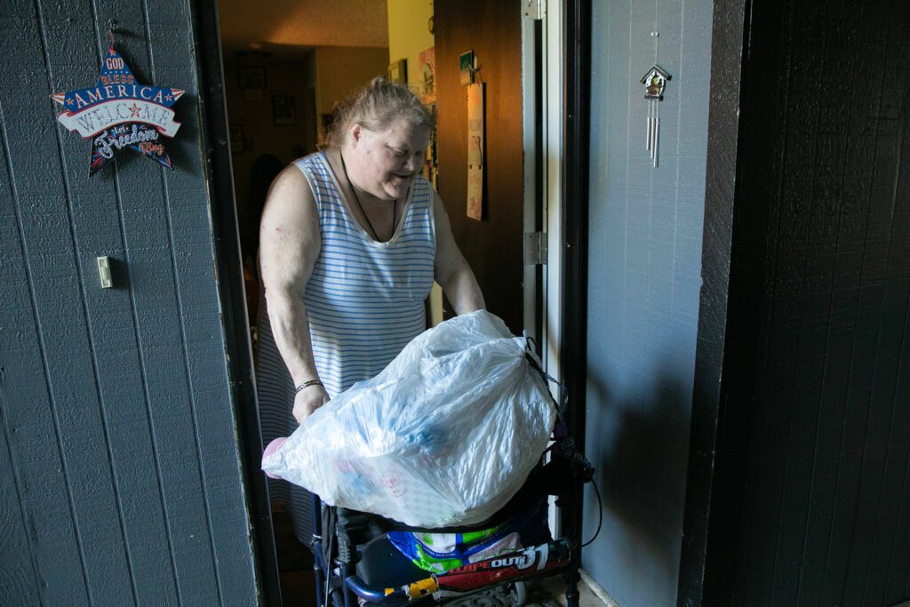 Jeanette Merkey, 54, exits her apartment to go take out the trash and recycling on Friday, June 7, 2024, in Everett, Washington. (Ryan Berry / The Herald)
